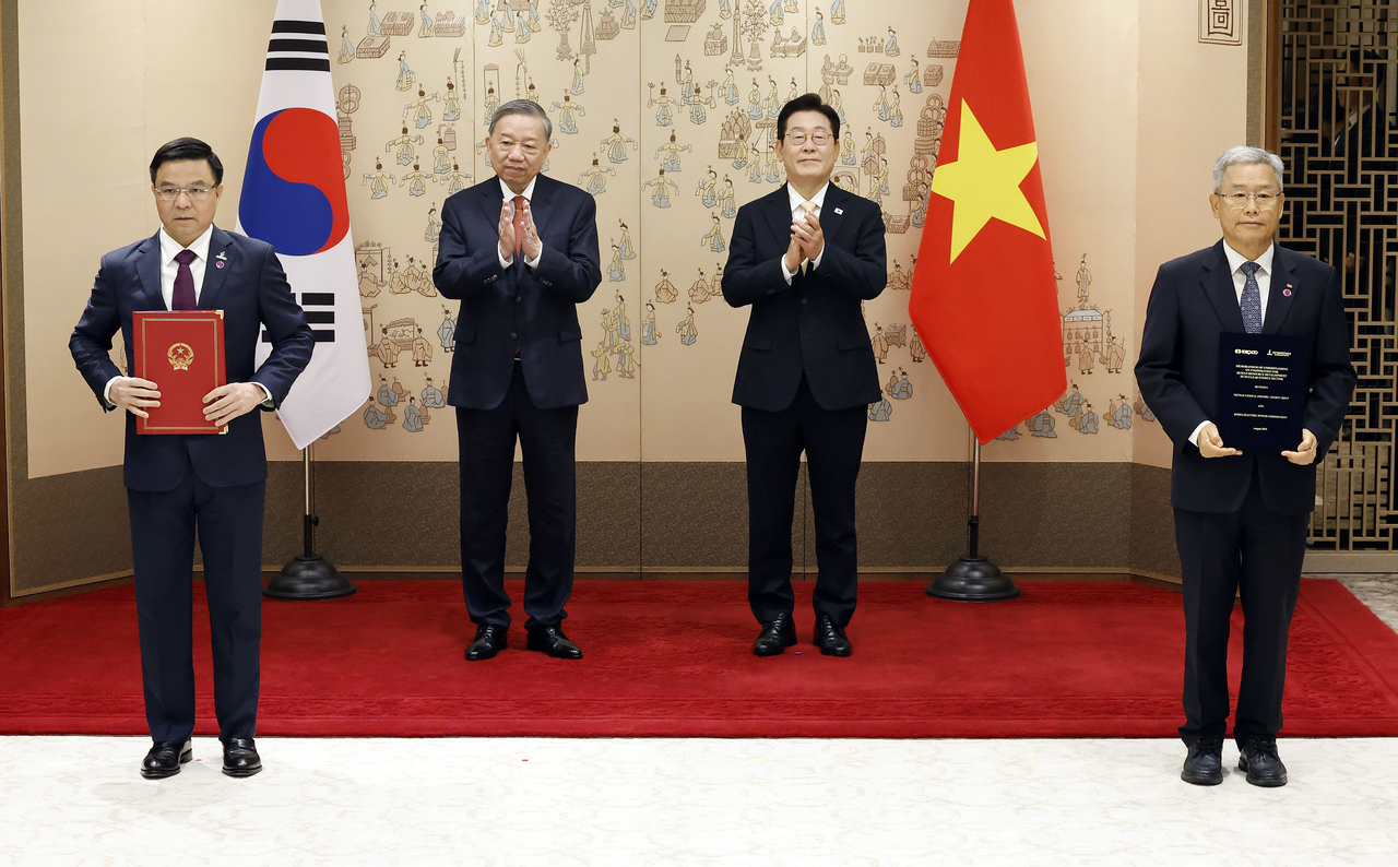 KEPCO President Kim Dong-cheol (right) and Petrovietnam President Le Manh Hung (left) pose after signing a nuclear power cooperation MOU at the presidential office in Seoul on Monday, joined by South Korean President Lee Jae Myung (second from right) and Vietnam’s top leader To Lam. (Yonhap)