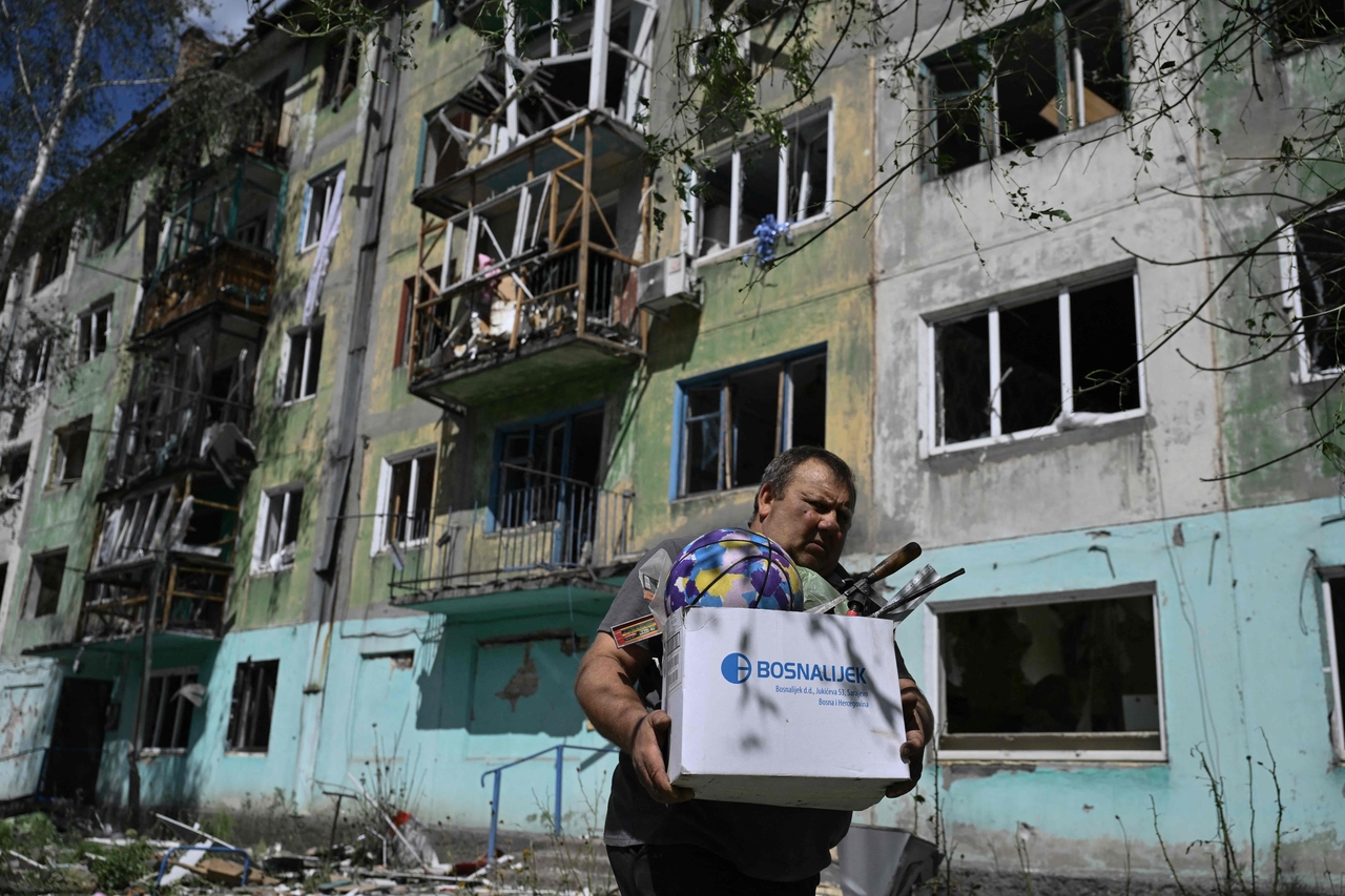 A resident carries belongings out of a damaged residential building following a Russian strike in the town of Bilozerske, Donetsk region, Tuesday.   AFP-Yonhap