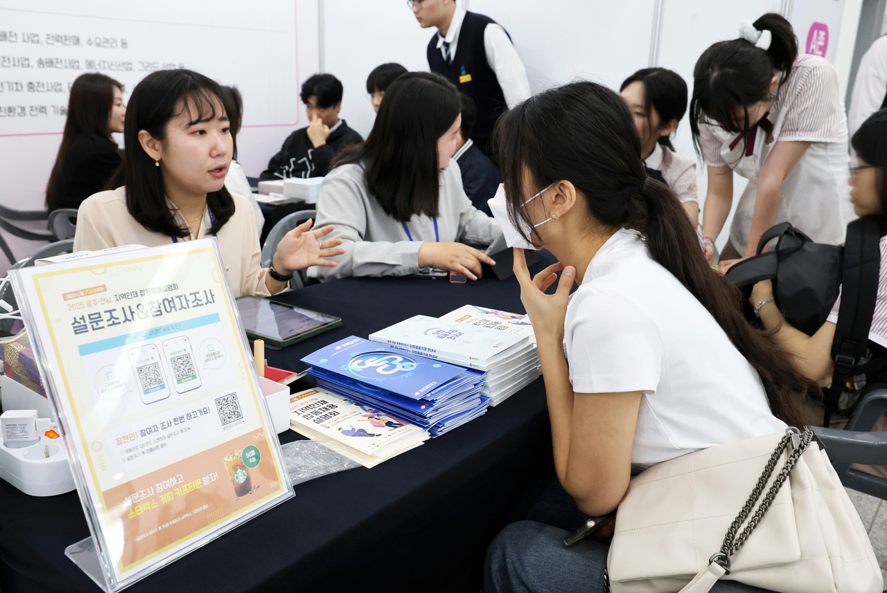 광주 북구 전남대학교 컨벤션홀에서 열린 ‘2025 광주·전남 지역인재 합동 채용설명회’에서 취업준비생들이 인사담당자의 설명을 듣고 있다. [연합]