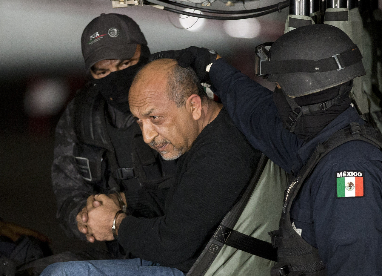 Mexican federal police escort Servando Gomez Martinez, leader of the Knights Templar cartel, as he sits inside helicopter in Mexico City in February. (AP-Yonhap)
