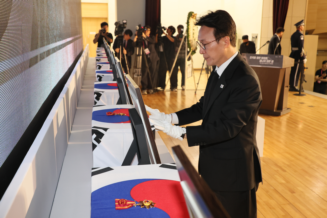 Prime Minister Kim Min-seok presents the Order of Merit for National Foundation during the repatriation ceremony for the remains of independence fighters previously buried overseas in Seoul on Wednesday. (Yonhap)