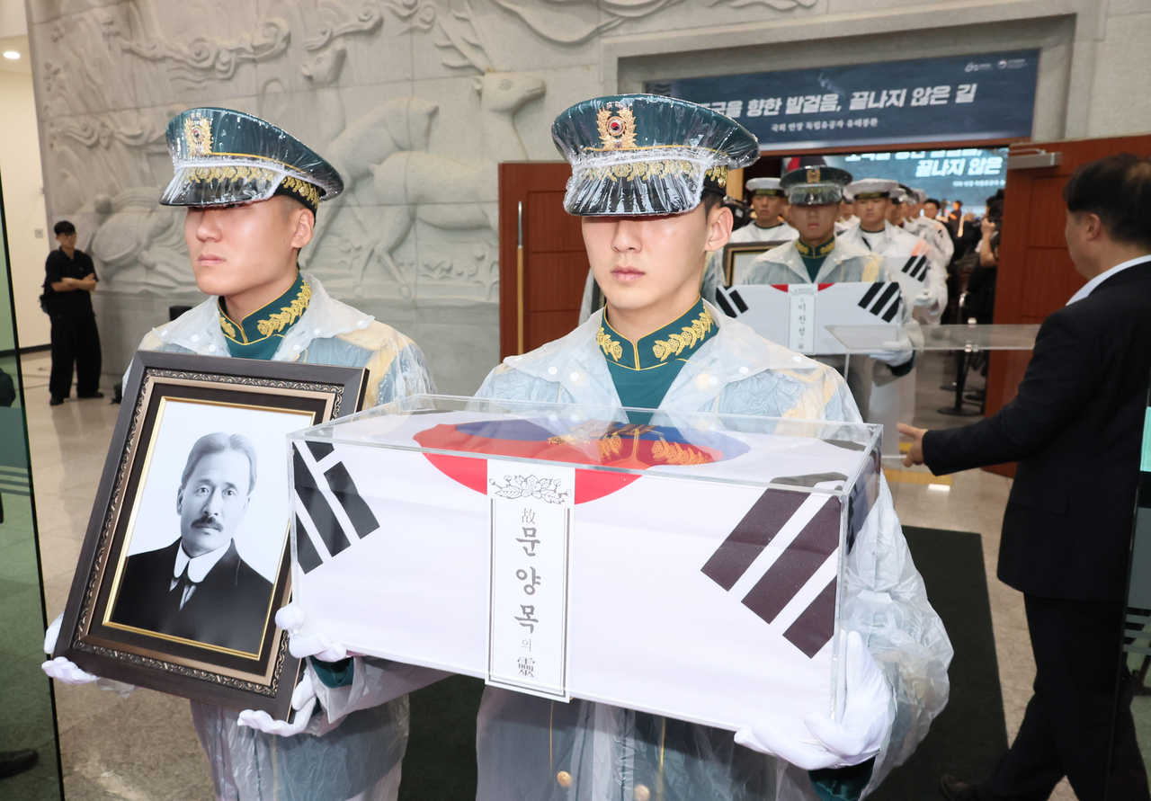 Military personnel carry the remains and a portrait of independence fighter Moon Yang Mok. (Yonhap)