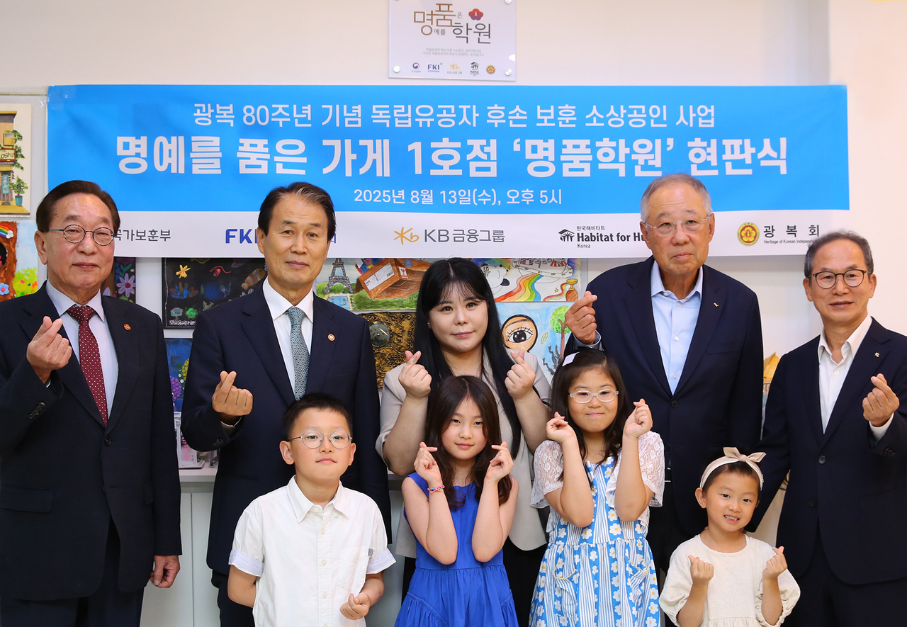 양종희(뒷줄 오른쪽부터) KB금융그룹 회장과 류진 한국경제인협회 회장, 독립유공자 김혁 선생 후손인 김수정 팔레트 미술교습소 원장, 권오을 국가보훈부 장관, 김진 광복회 부회장이 13일 서울 도봉구에서 열린 명품가게 1호점 현판식에서 기념촬영을 하고 있다.  [KB금융 제공]