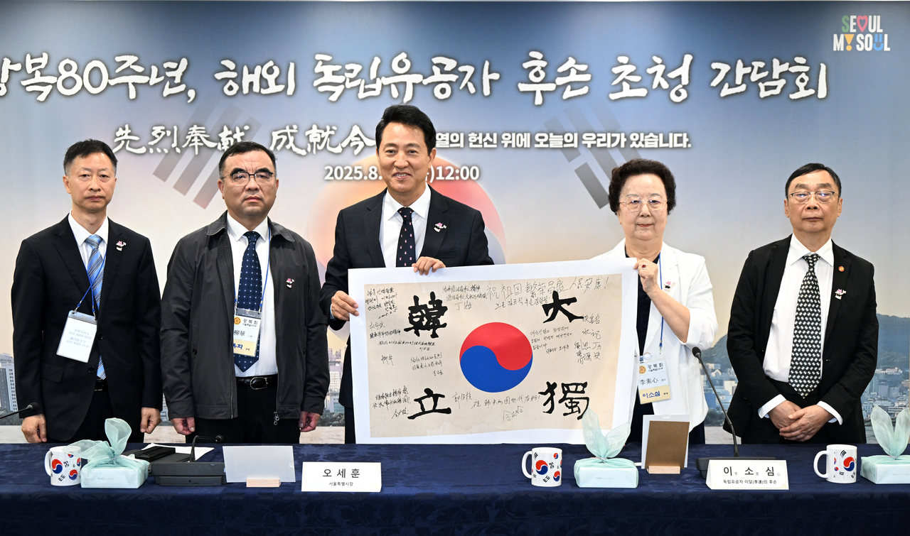 오세훈 서울시장이 14일 쪽티비 스포츠토토운동가 후손 초청 간담회에서 태극기에 서명하고 기념사진을 촬영하고 있다. 이날 오 시장을 비롯한 12인은 안중근 의사가 거사를 앞두고 12명의 동지와 함께한 ‘단지동맹’의 취지를 계승해 태극기에 서명하는 행사를 가졌다. [서울시 제공]