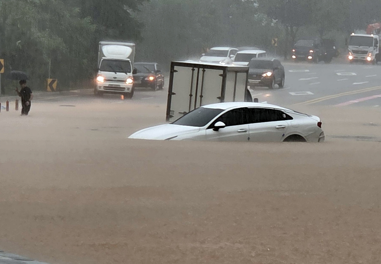 Cars partially submerged on a flooded road in Goyang, Gyeonggi Province, on Wednesday. (Yonhap)