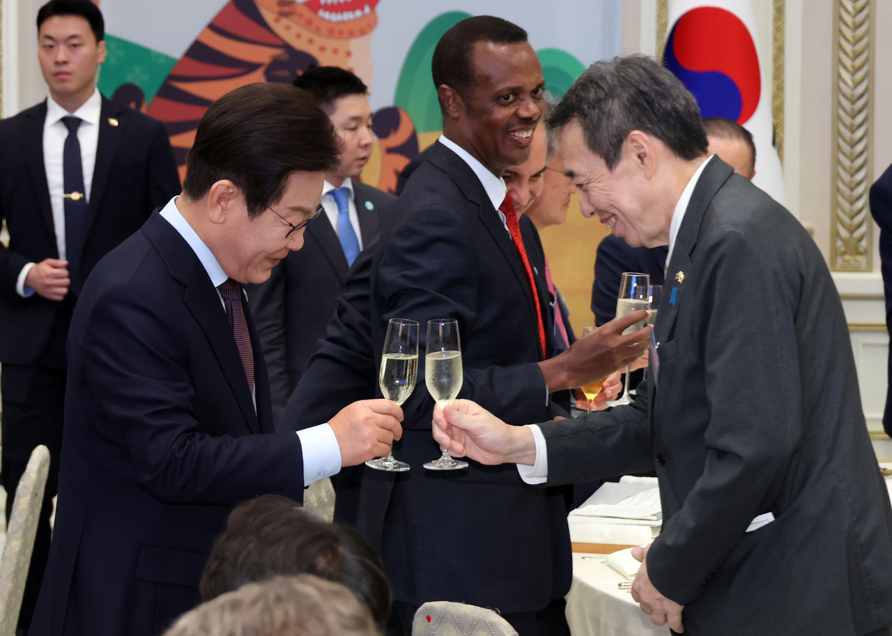 President Lee Jae Myung raises a toast with Japanese Ambassador to Korea Koichi Mizushima at the "Dinner with the President for the Diplomatic Corps" event at Cheong Wa Dae in Jongno-gu, central Seoul, Friday. (Yonhap)