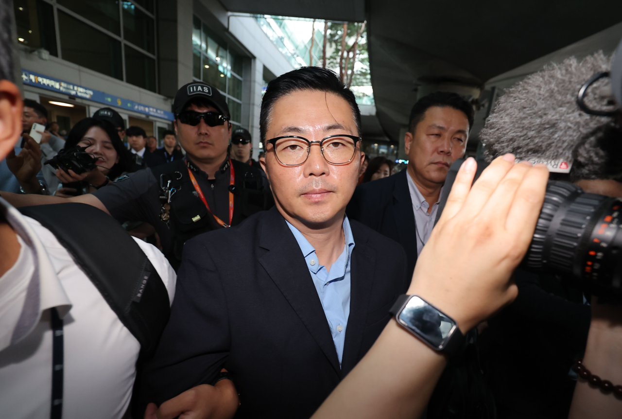 Kim Ye-seong (center), an associate of former first lady Kim Keon Hee, is taken in for questioning by a special counsel upon arrival at Incheon International Airport, west of Seoul, from Vietnam on Tuesday. (Yonhap)