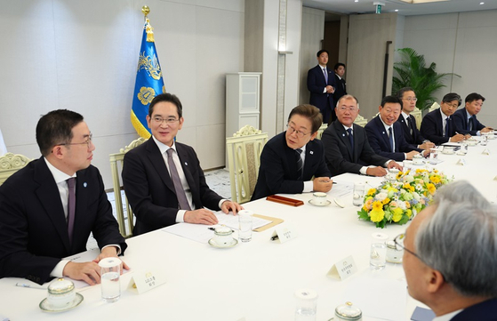 From left: LG Group Chairman Koo Kwang-mo, Samsung Electronics Chairman Lee Jae-yong, President Lee Jae Myung, Hyundai Motor Group Executive Chair Chung Euisun, Lotte Group Chairman Shin Dong-bin, Acting Finance Minister Lee Hyoung-il and Presidential Secretary for Industrial Affairs Yoon Sung-hyuk are in a discussion in the presidential office in Seoul in June. (Joint Press Corps)