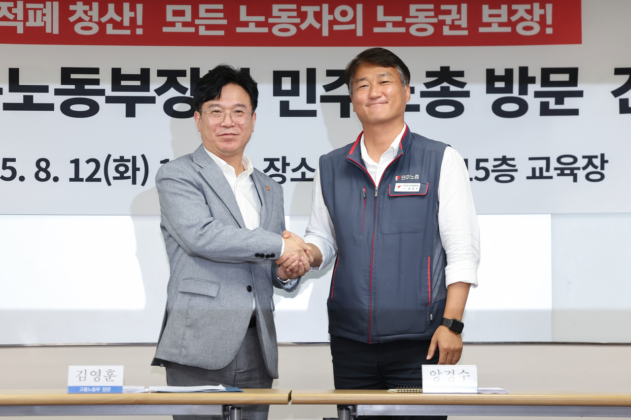 김영훈 고용노동부 장관(왼쪽)이 12일 서울 중구 전국민주노동조합총연맹(민주노총)을 찾아 양경수 민주노총 위원장과 악수하며 인사를 나누고 있다. [연합]