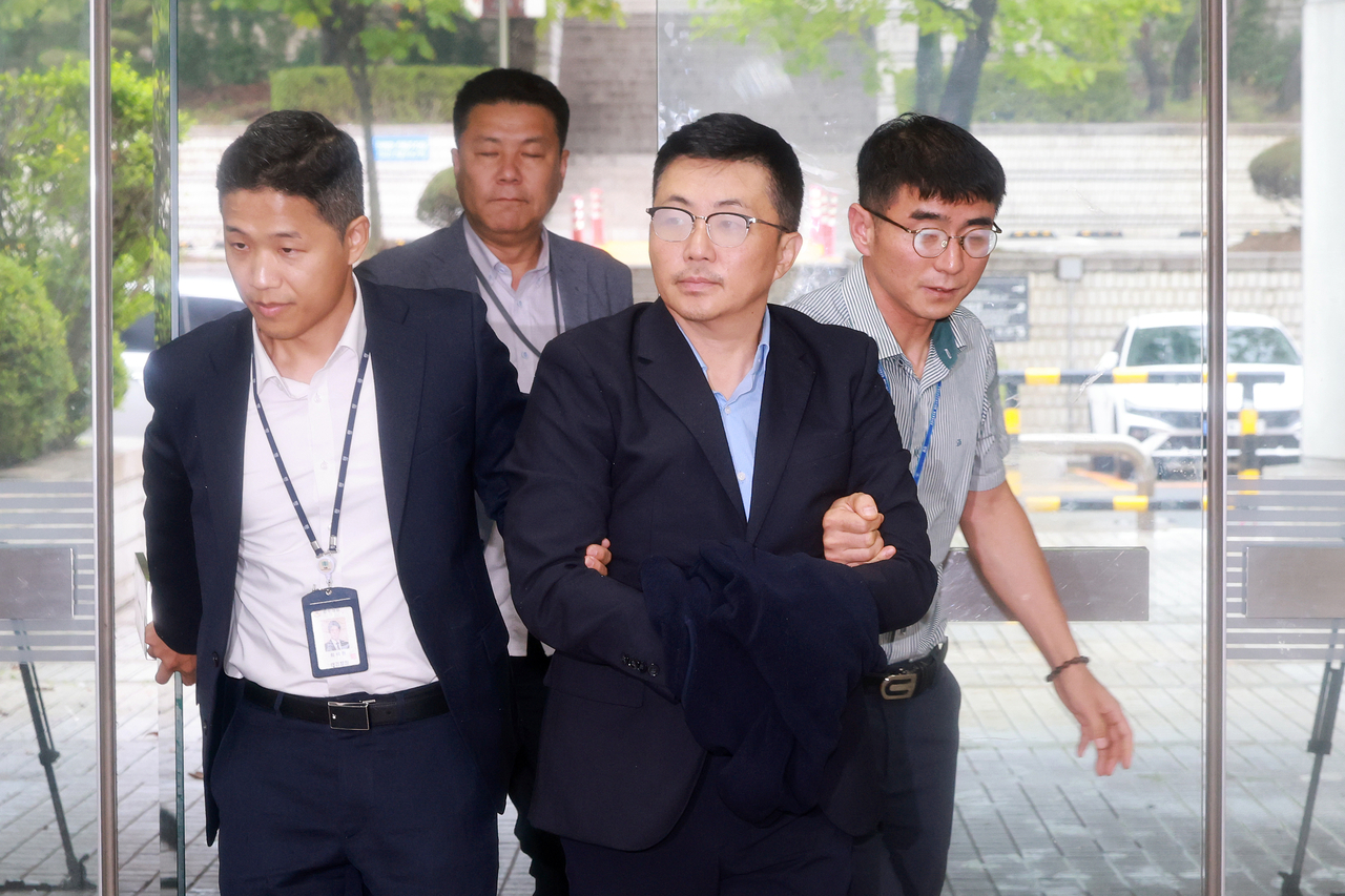 Kim Ye-seong (third from left), an associate of former first lady Kim Keon Hee, arrives at the Seoul Central District Court to attend his arrest warrant hearing on Friday. (Yonhap)