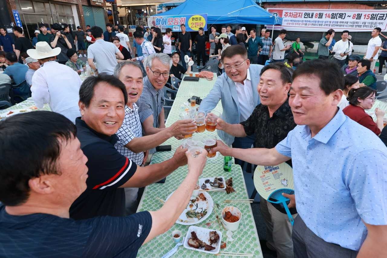 경북 예천군 예천읍 상설시장에서 15일 오후 열린 ‘맥주 페스티벌’에서 김학동 예천군수가 참가자틈에서 건배를 하고 있다. [예천군 제공]