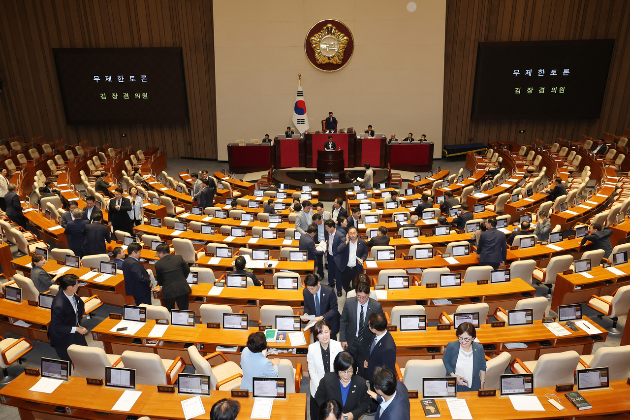Lawmakers of the ruling Democratic Party of Korea walk out of the National Assembly as the main opposition filibusters a bill during a plenary session on Aug. 5. (Yonhap)