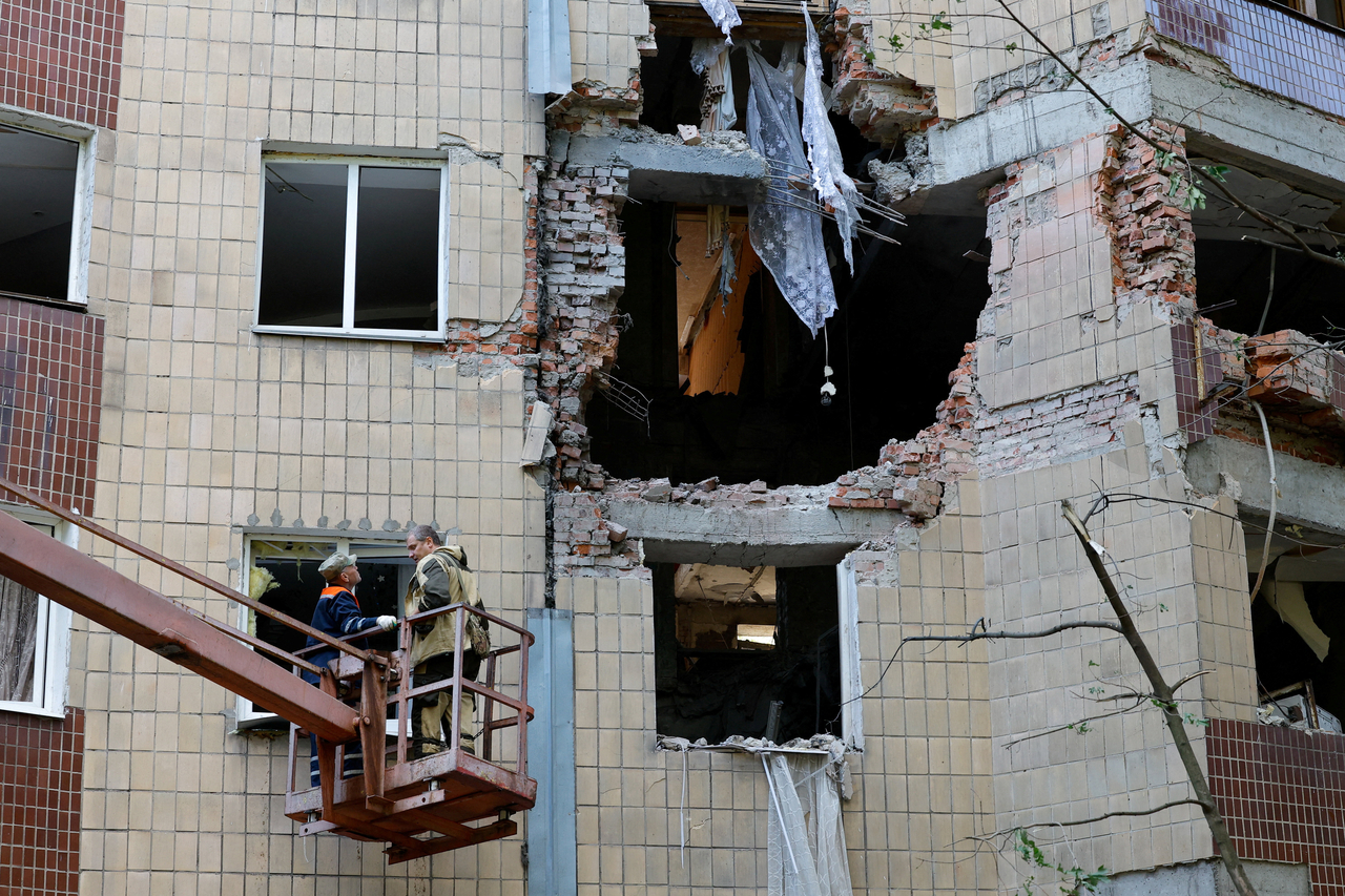Workers remove debris in a block of flats damaged by overnight shelling in Donetsk, a Russian-controlled city of Ukraine, Saturday. (Reuters-Yonhap)