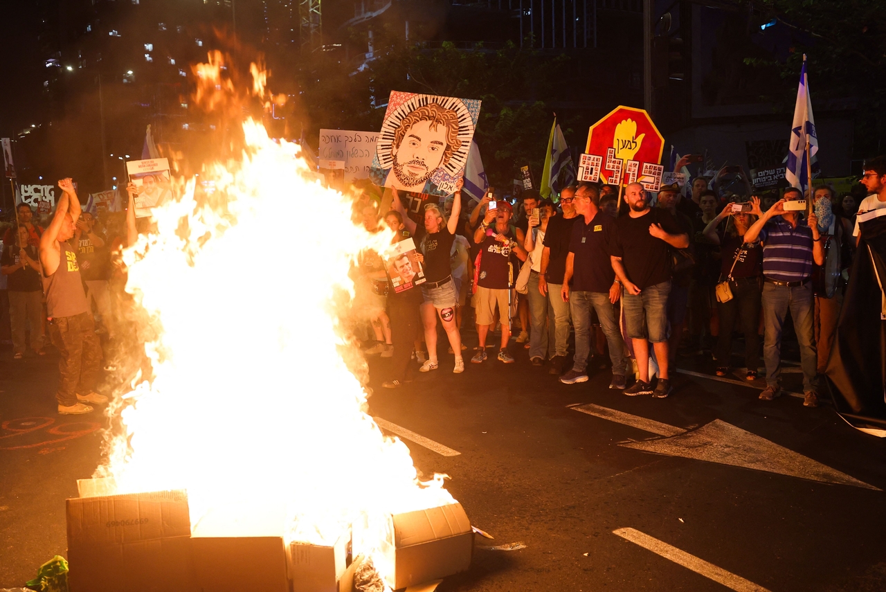 People lift placards during a demonstration in Tel Aviv, Israel, Saturday. (AFP-Yonhap)