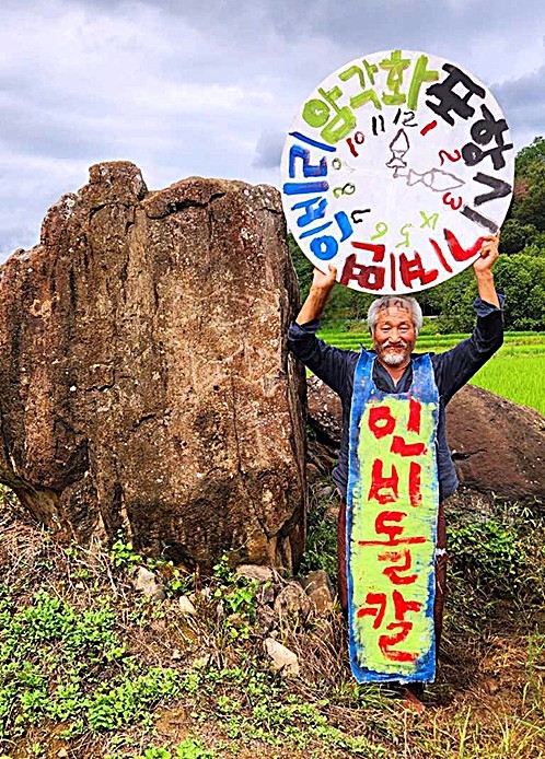 18일 서예가 쌍산 김동욱 씨가  포항시 북구 기계면 인비리 암각화 앞에서 열린 암각화 보존·관리 촬영대회에 참여해 퍼포먼스를 펼치고 있다. [쌍산 김동욱씨 제공]