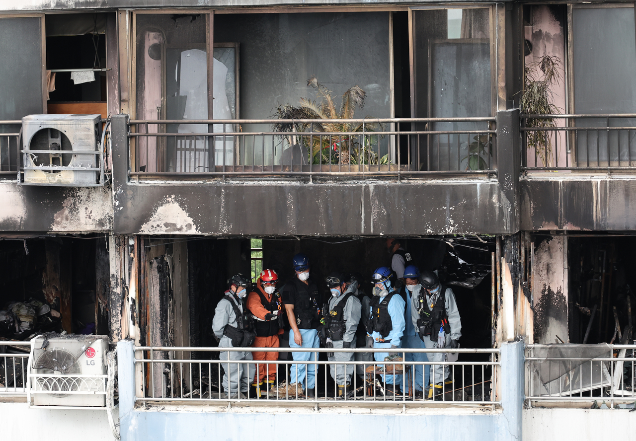Police and fire authorities conduct a joint forensic investigation at an apartment complex in Mapo-gu, western Seoul, Monday, where a fire killed two and injured 13 the day before. (Yonhap)