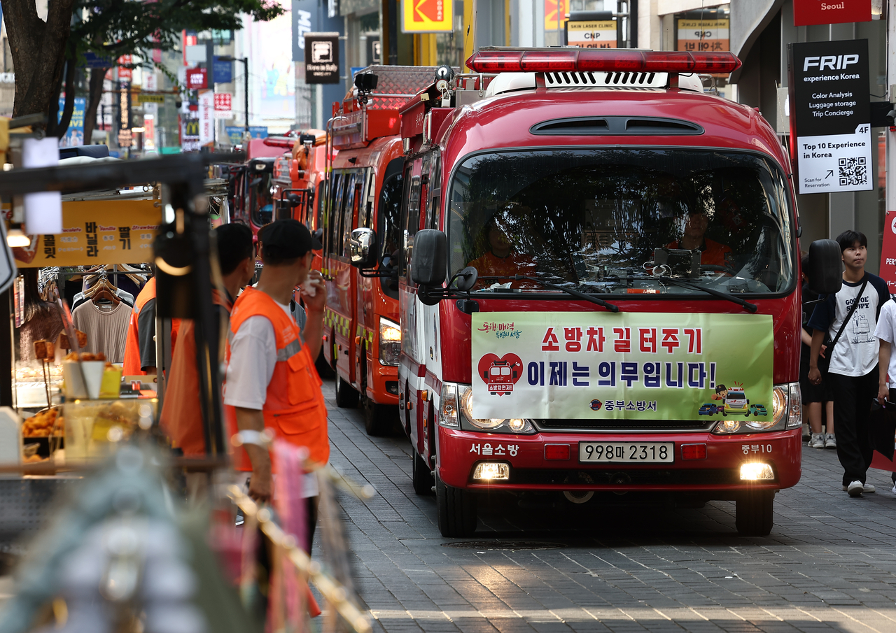 In this unrelated photo, civilians make way for fire engines passing by in an alley at Myeong-dong in Jung-gu, central Seoul, July 24. (Yonhap)