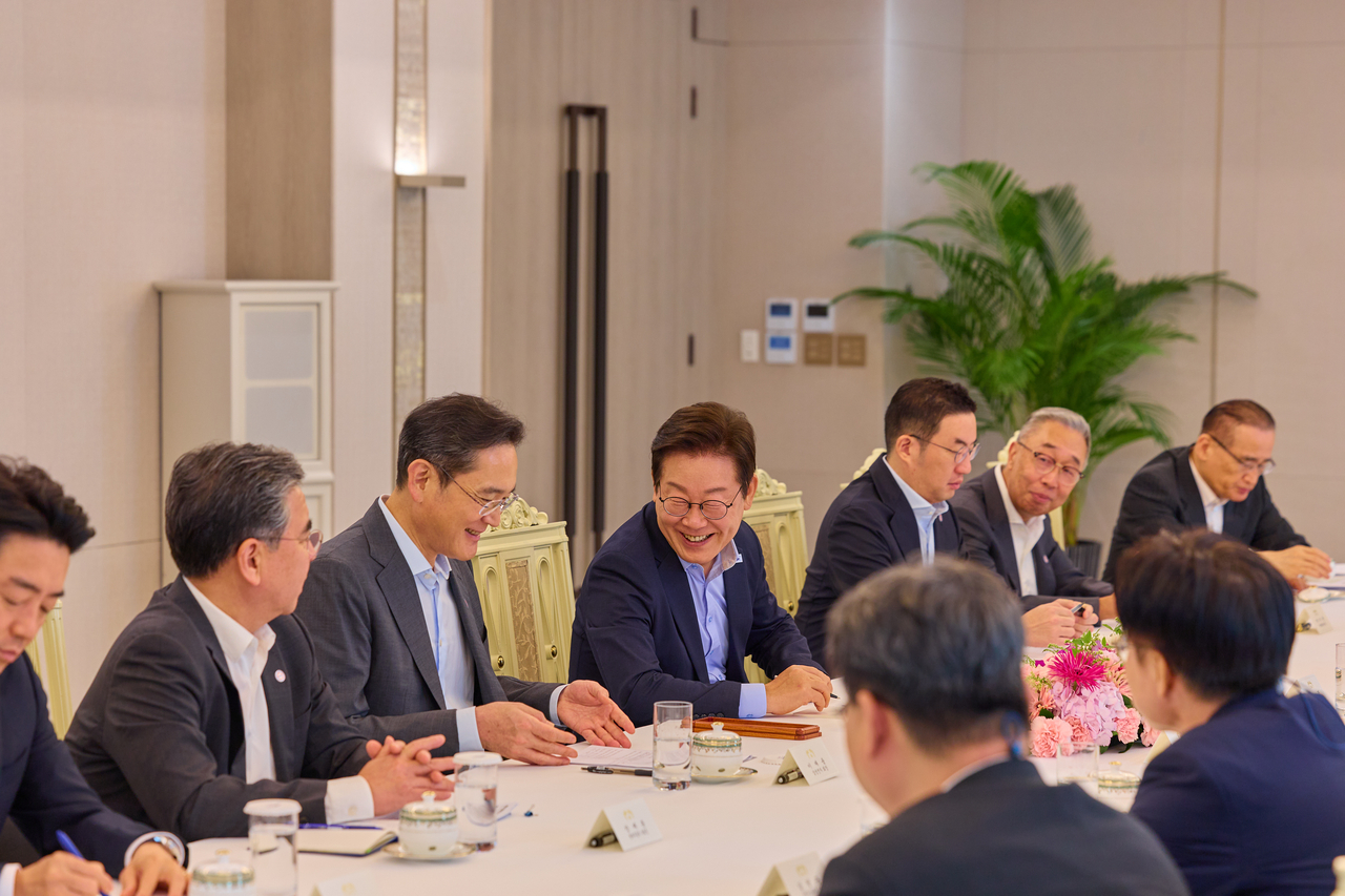 Samsung Electronics Chair Lee Jae-yong (third from left) and President Lee Jae Myung (fourth from left) talk during a business roundtable with chaebol leaders at the presidential office in Seoul on Tuesday. (Presidential office)