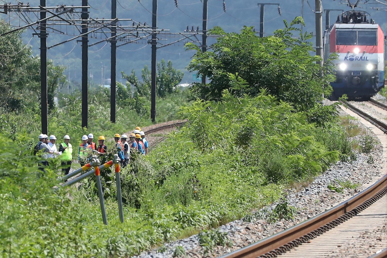 Investigators inspect the site where a train hit seven people on Tuesday, killing two. (Cheongdo Fire Station)