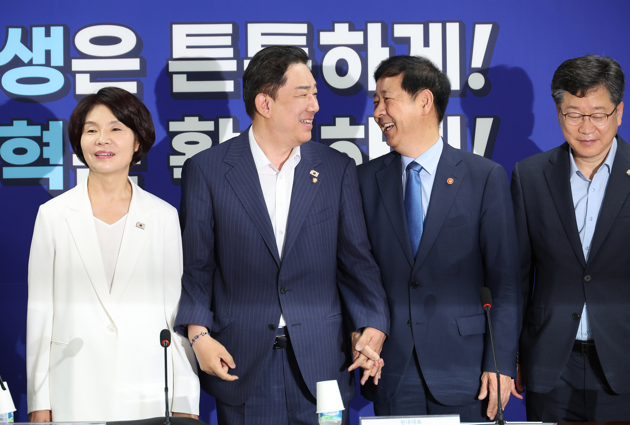 Rep. Kim Byung-kee (center left), floor leader of the Democratic Party of Korea, speaks with Finance Minister Koo Yun-cheol (center right) during a photo session at a policy consultation meeting at the National Assembly in Seoul on Wednesday. (Yonhap)