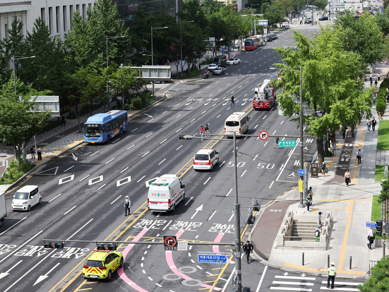 Fire trucks and ambulances move through the usually busy road near City Hall in central Seoul on Wednesday afternoon, as part of the 20-minute civil defense drill. (Yonhap)