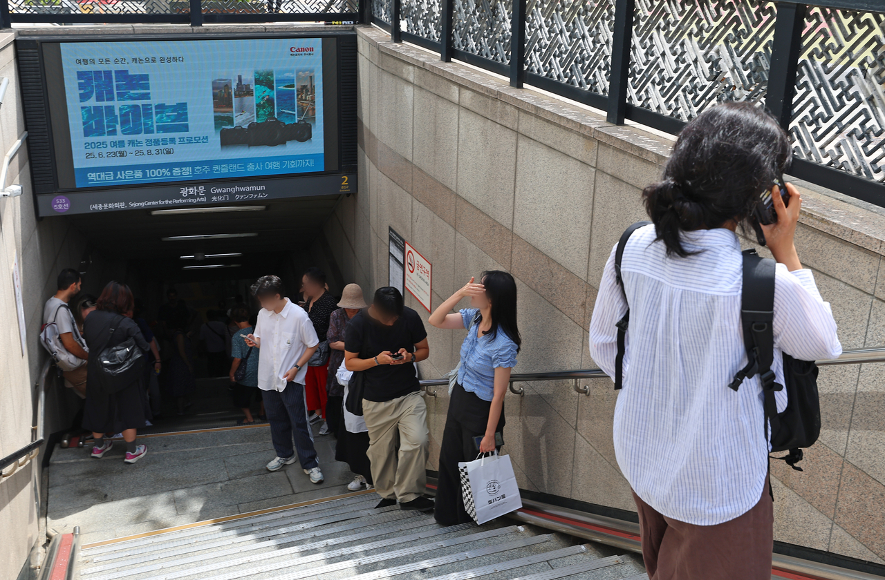 Citizens take shelter on the stairway of a subway station as a 20-minute civil defense exercise gets underway on Wednesday in Seoul. (Yonhap)