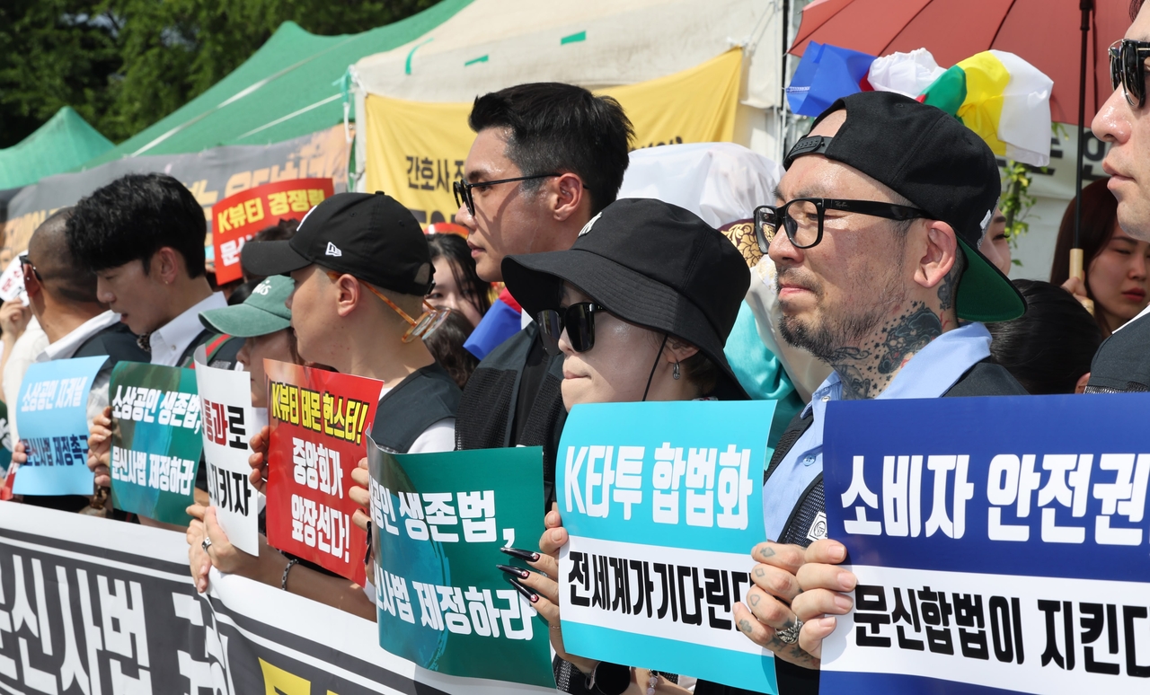 Demonstrators stand shoulder to shoulder holding placards demanding passage of the Tattooist Act in front of the National Assembly in Seoul on Wednesday. (Yonhap)