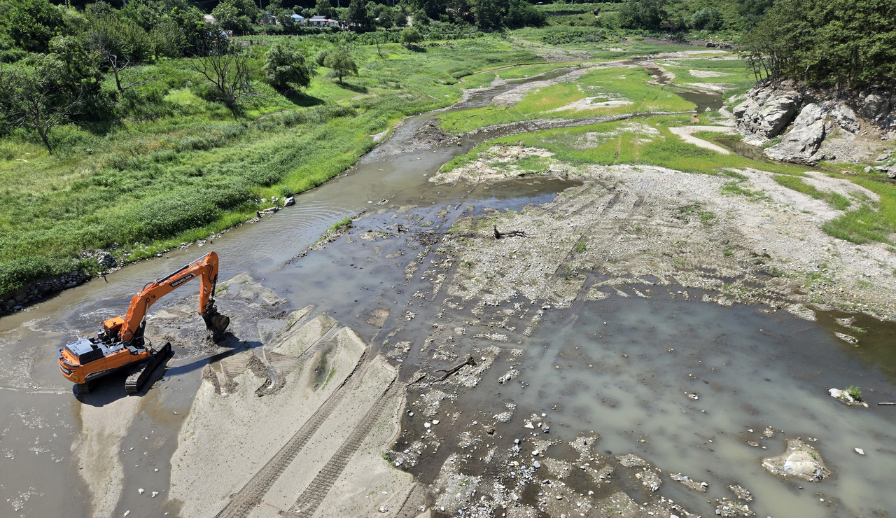 Emergency maintenance work is being carried out at the Obong Reservoir in Gangneung, Gangwon Province with an excavator to ensure the smooth inflow of water into the distribution system on Friday, as water storage levels reached a record low at 19 percent. (Yonhap)
