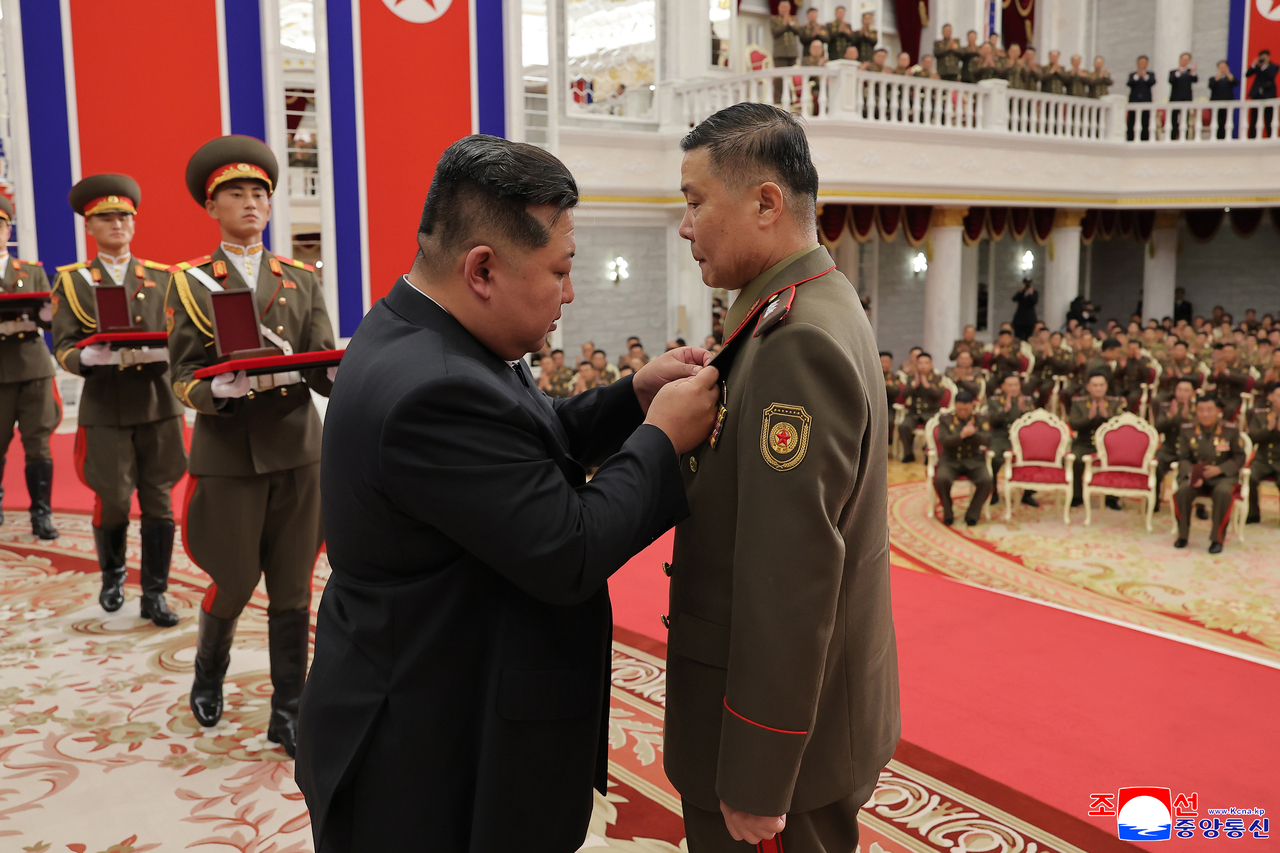 This photo carried by North Korea's official Korean Central News Agency on Friday, shows the North's leader awarding the title of "Hero of the Republic" to service members who were deployed to Russia's war with Ukraine. (Yonhap)