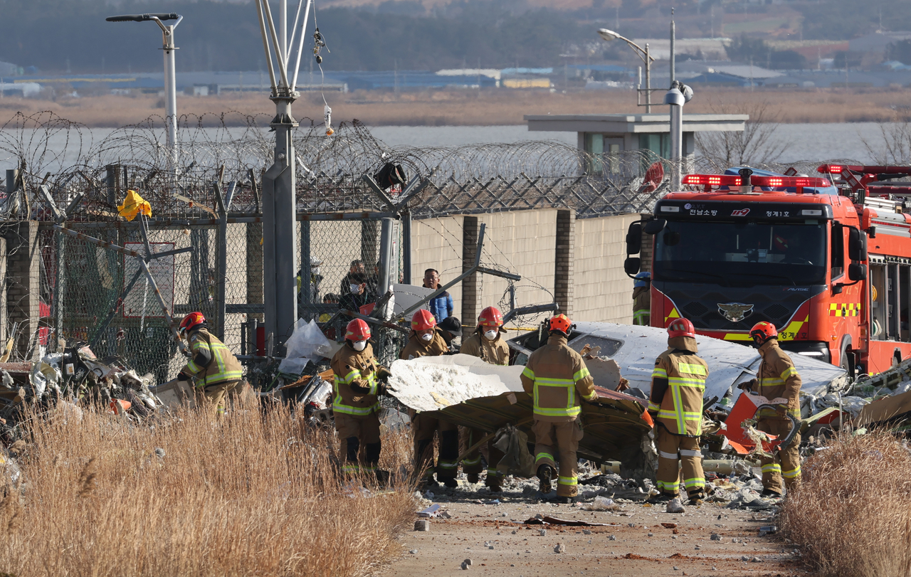 Firefighters carry out a rescue operation at the scene of the Jeju Air plane crash at Muan International Airport in South Jeolla Province on Dec. 29, 2024, where a passenger aircraft crashed during an emergency landing, killing 179 of the 181 people on board. (Korea Herald DB)