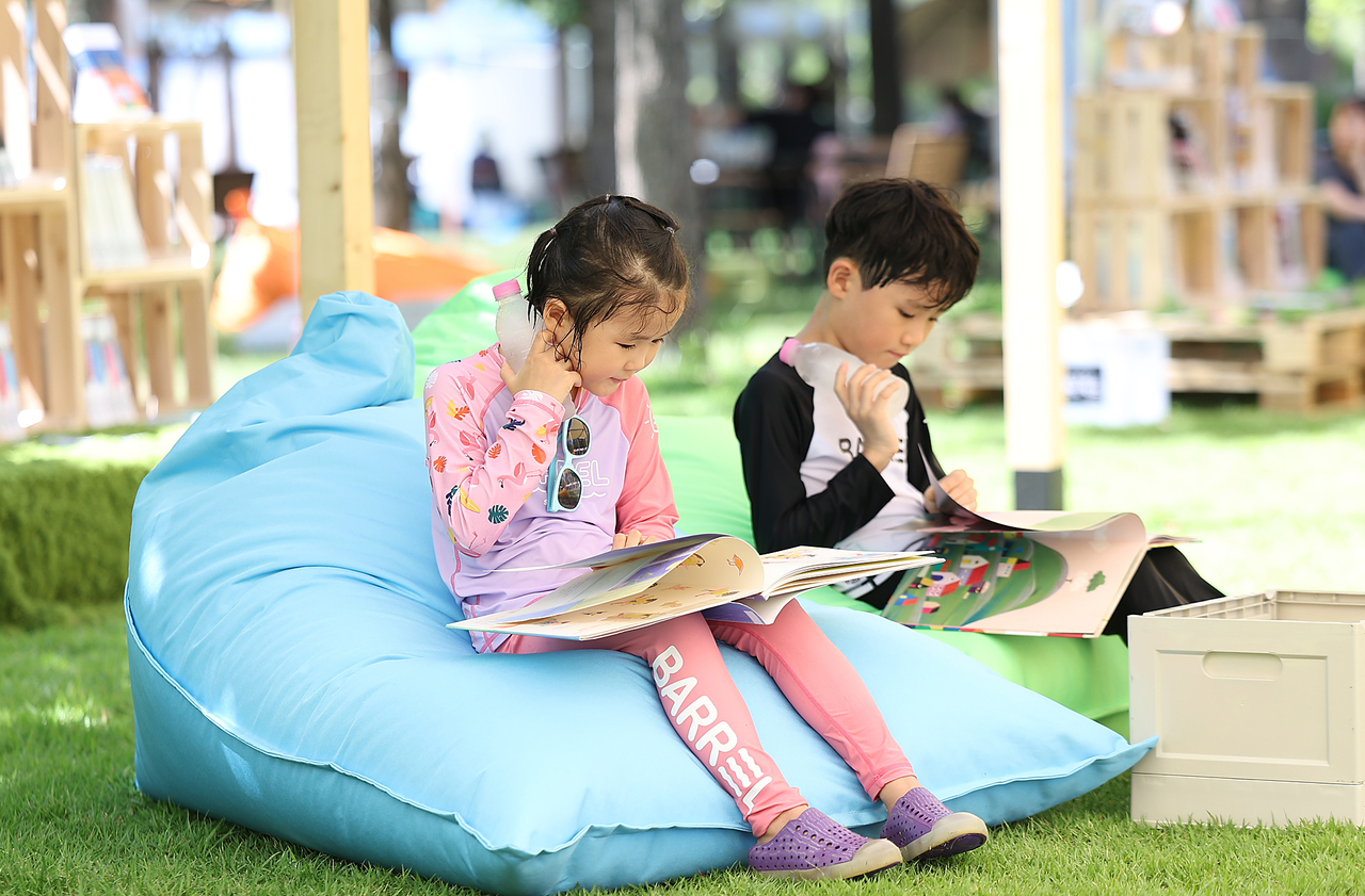 지난달 29일 대구 수성구 수성패밀리파크에서 어린이들이 책을 보며 더위를 식히고 있다. [연합]