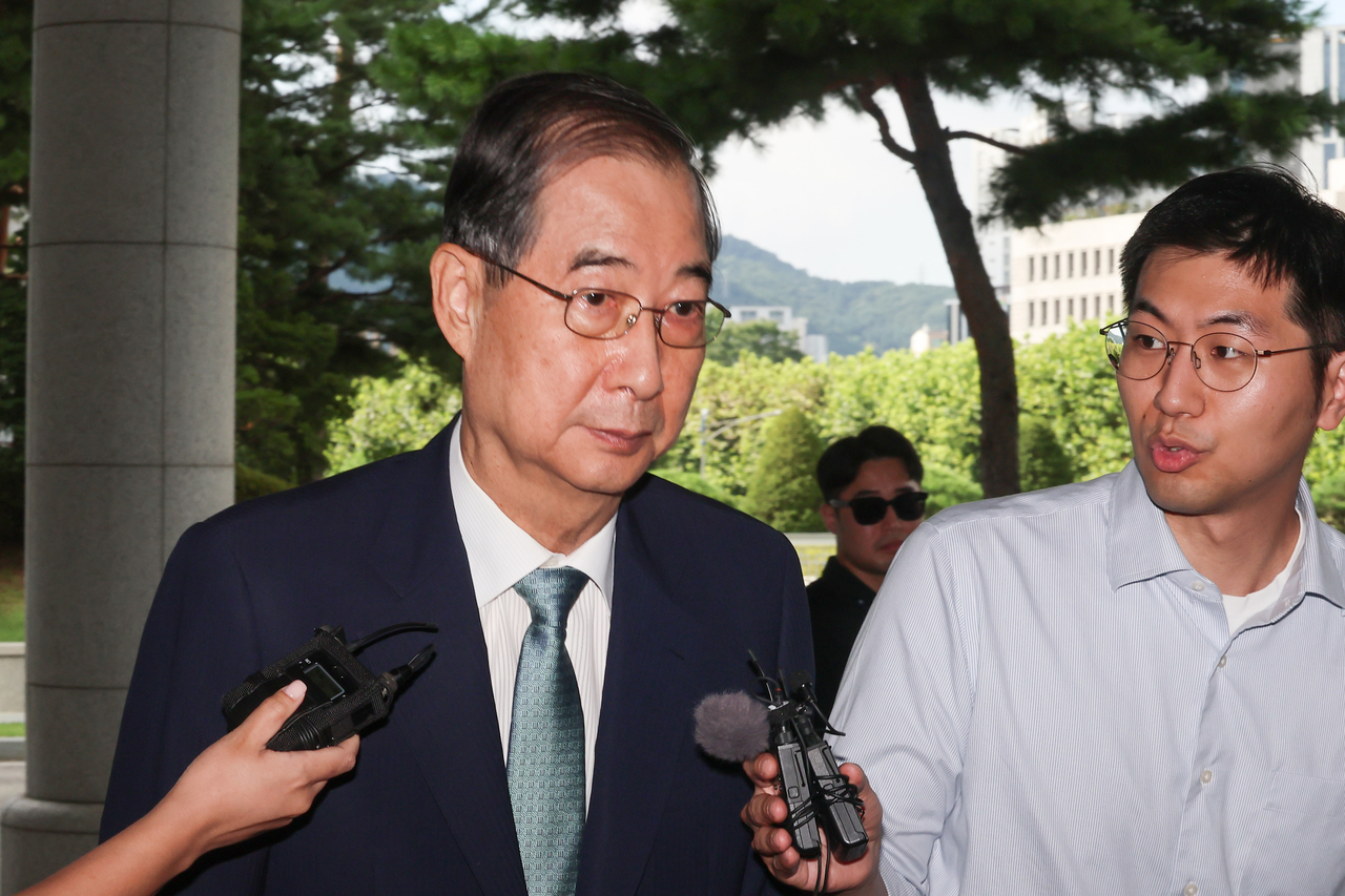 Former Prime Minister Han Duck-soo (left) arrives at special counsel Cho Eun-suk's office in southern Seoul on Aug. 22, 2025, to undergo questioning over his alleged involvement in former President Yoon Suk Yeol's martial law declaration. (Yonhap)