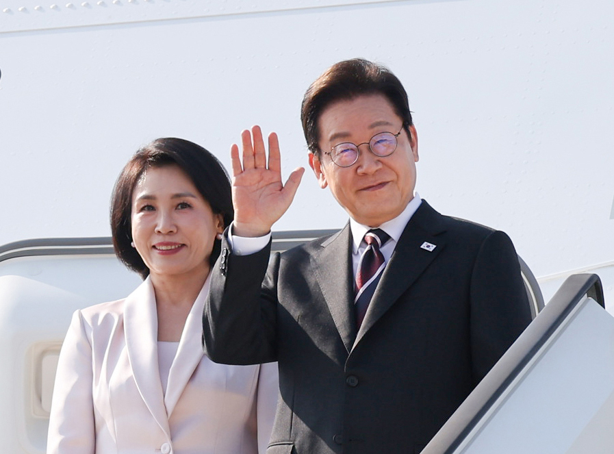 President Lee Jae Myung (right) and his wife Kim Hea Kyung board Air Force One at Haneda Airport in Tokyo to fly to Washington on Sunday. (Yonhap)