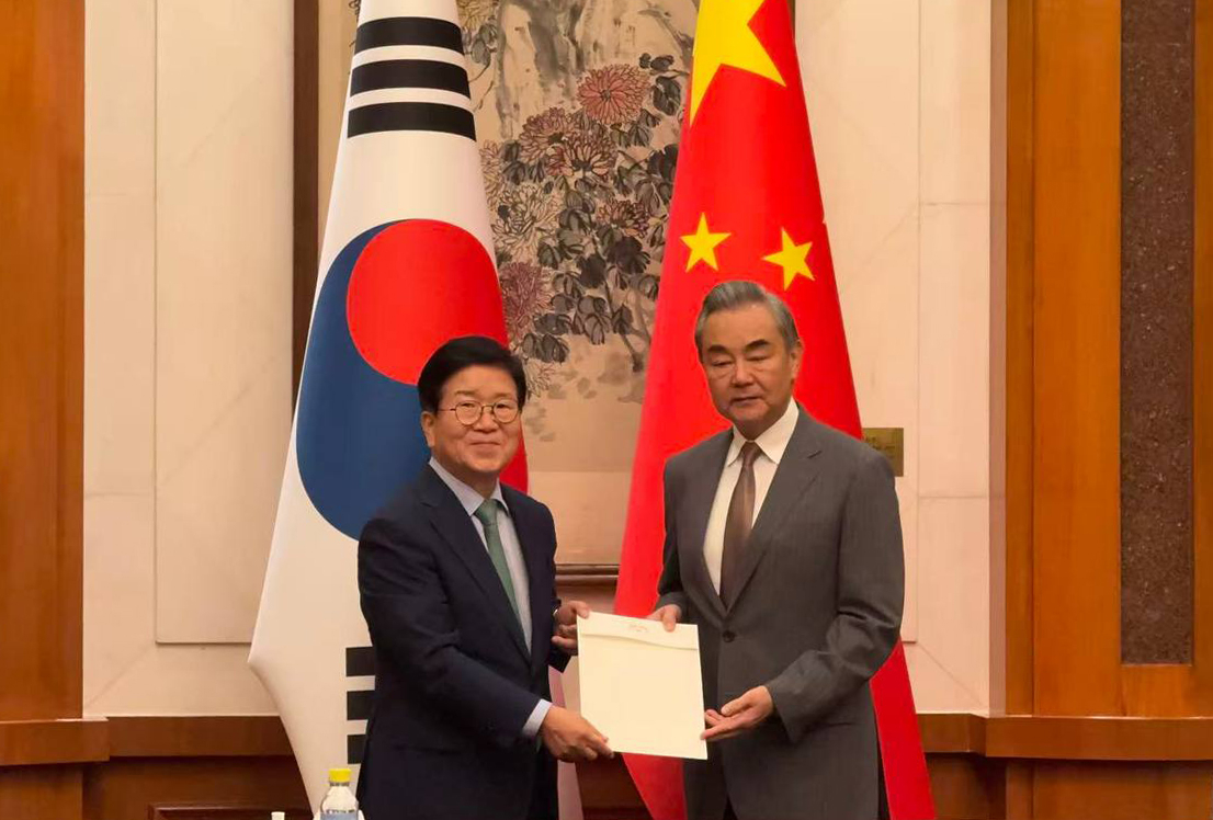 Former National Assembly Speaker Park Byeong-seug (left) delivers President Lee Jae Myung's personal letter for Chinese President Xi Jinping during his meeting with Chinese Foreign Minister Wang Yi in Beijing on Aug. 24, 2025. (Yonhap)