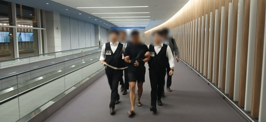 국제토토사이트 모멘트조직 총책 중국인 A씨가 22일 국내로 송환되고 있다. [법무부 제공]