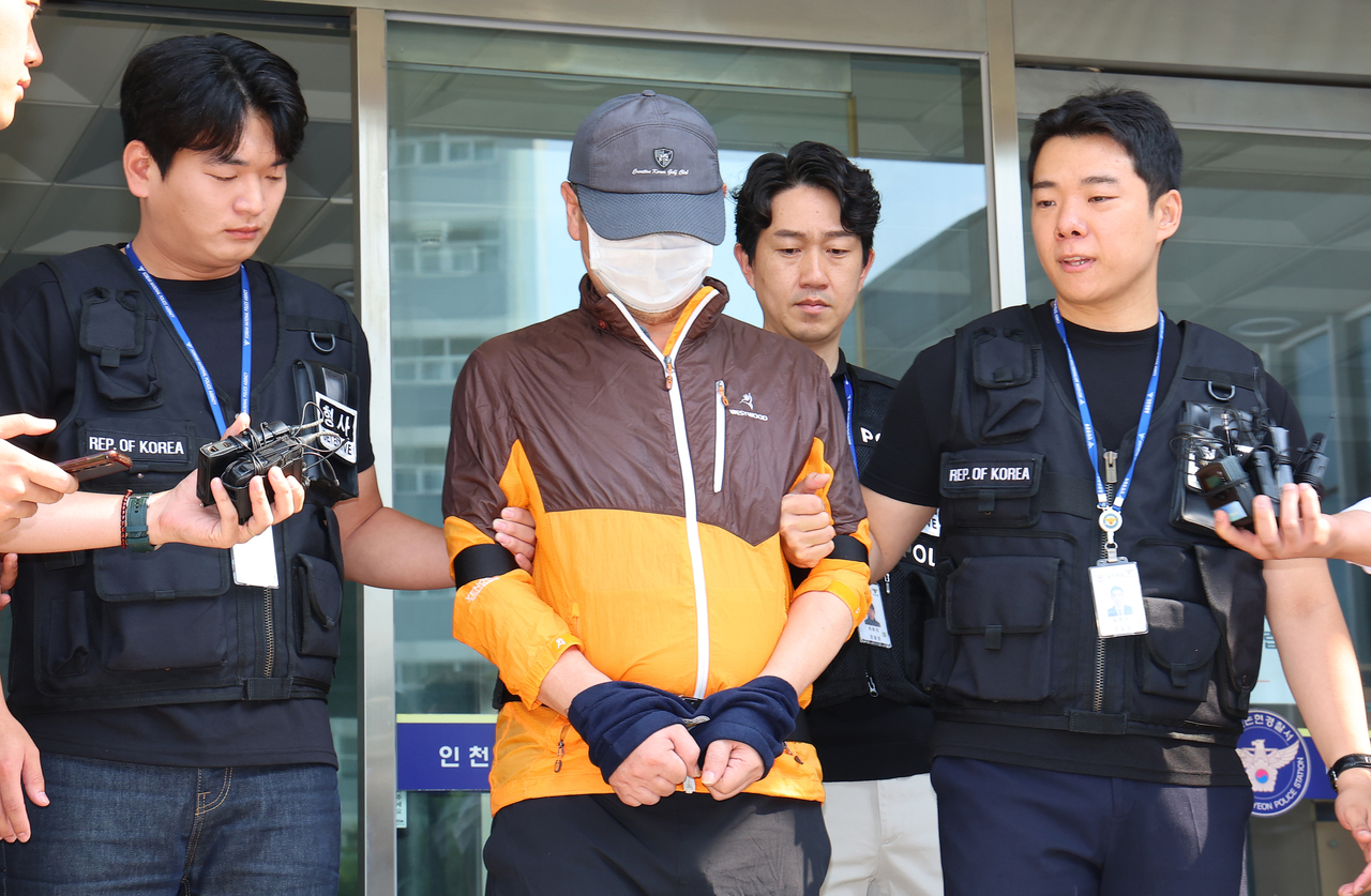 A 62-year-old man suspected of killing his son is escorted to the public prosecutors' office by officers of Nonhyeon Police Station in Incheon on July 30. (Yonhap)