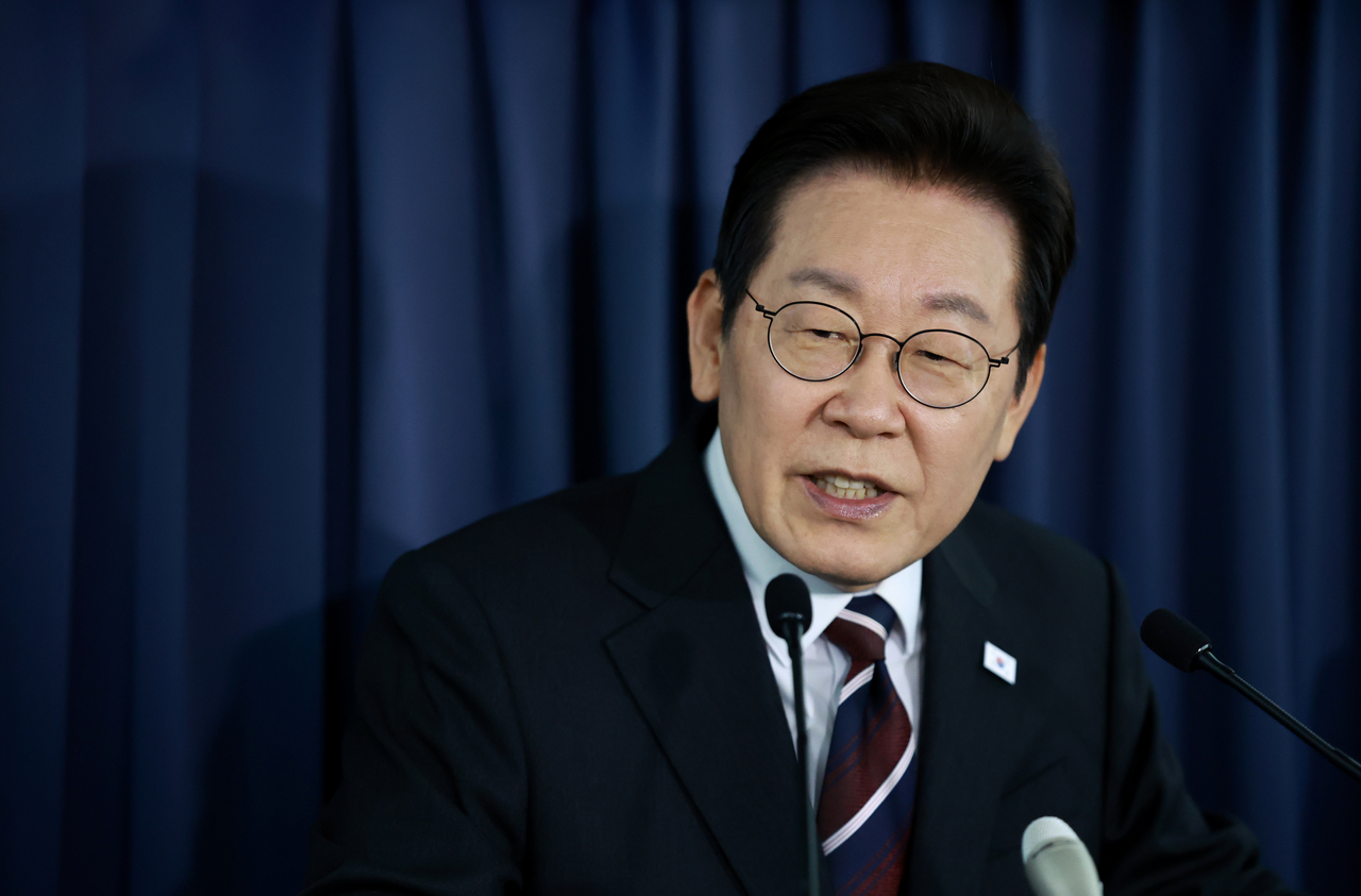 President Lee Jae Myung speaks at a press conference during his flight to the United States for his summit with US President Donald Trump on Sunday. (Yonhap)