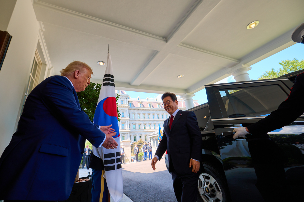 President Lee Jae Myung (right) is greeted by US President Donald Trump at the White House in Washington on Monday. (Joint Press Corps via Yonhap)