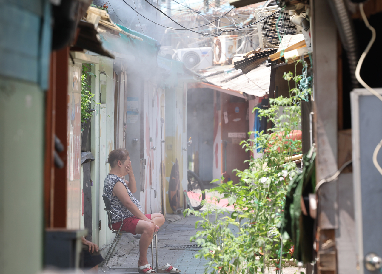 A resident sits in an alley at a “jjokbangchon” in Yeongdeungpo-gu, western Seoul, on July 9. A jjokbangchon is a cluster of single-room villages, mostly consisting of older adults in low-income groups. (Yonhap)