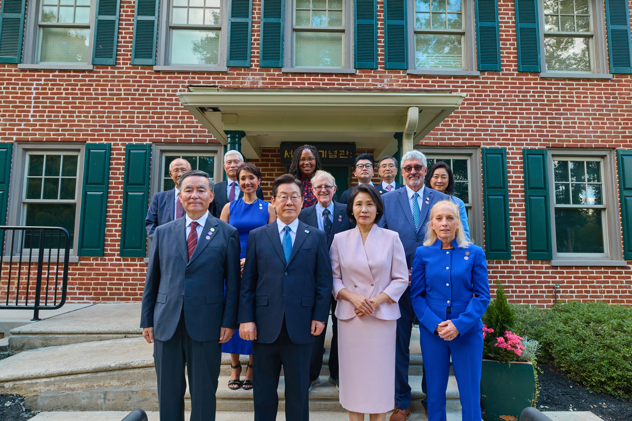President Lee Jae Myung (front row, second from left) and First Lady Kim Hye Kyung (third from left) pose for a photo with officials from South Korea and the United States, including Seo Jae-pil Memorial Foundation Chairman Choi Jung-soo (far left), and US Rep. Mary Gay Scanlon (far right) on Tuesday. (Yonhap)