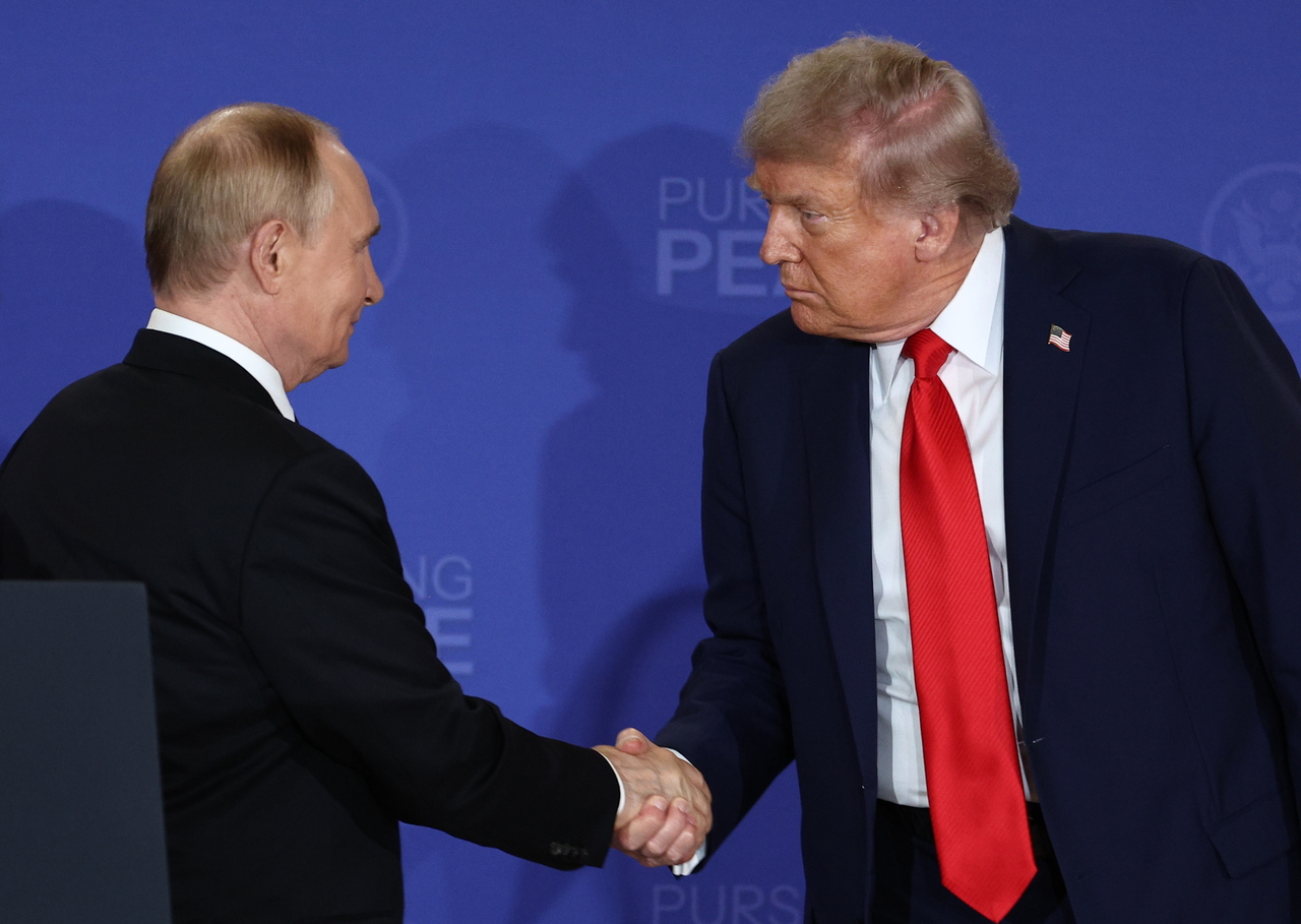 Russian President Vladimir Putin (left) and US President Donald Trump shake hands in Anchorage, Alaska, Aug. 15. (EPA-Yonhap)