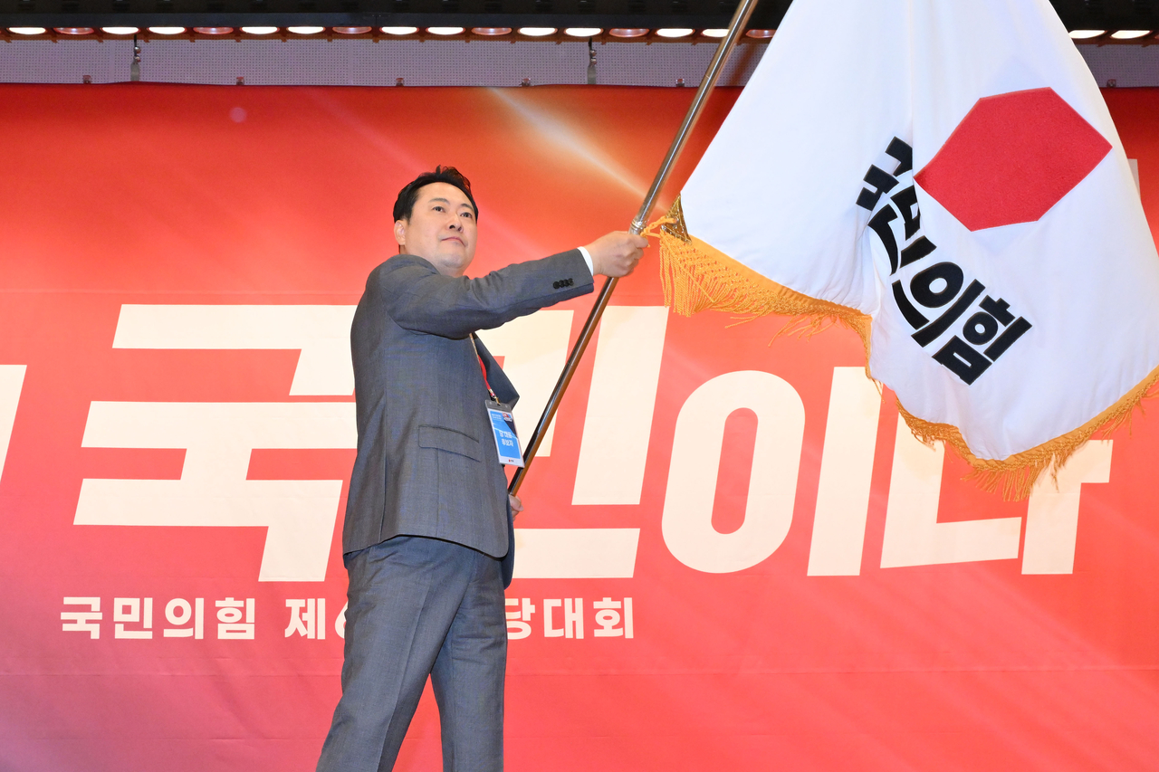 Rep. Jang Dong-hyeok, newly elected as the leader of the main opposition People Power Party, waves the party’s flag after his acceptance speech at the National Assembly in Seoul on Tuesday. (Joint Press Corps via Yonhap)