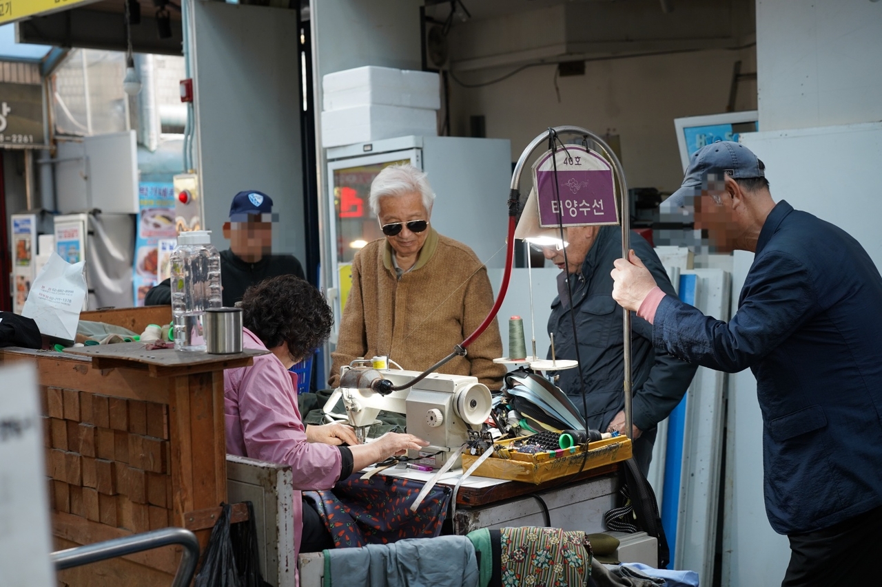 Visitors wait in line to get their jackets and trousers tailored at Jongno Sinjin Market in Jongno-gu, central Seoul. (Lee Si-jin/The Korea Herald)