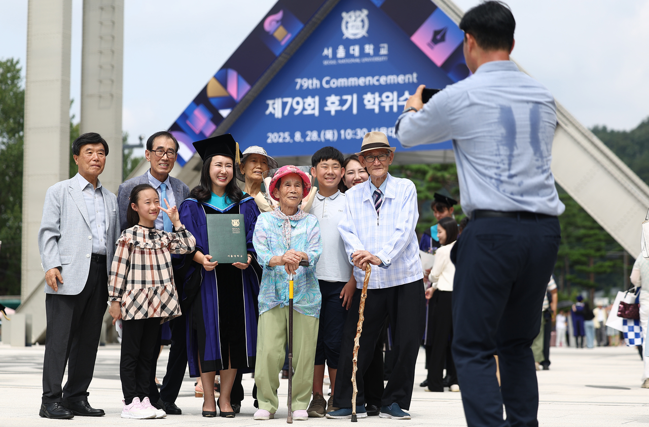 A graduate poses for a commemorative photo with her family during the 79th Commencement Ceremony held at Seoul National University in Gwanak-gu, Seoul, Thursday. (Yonhap)