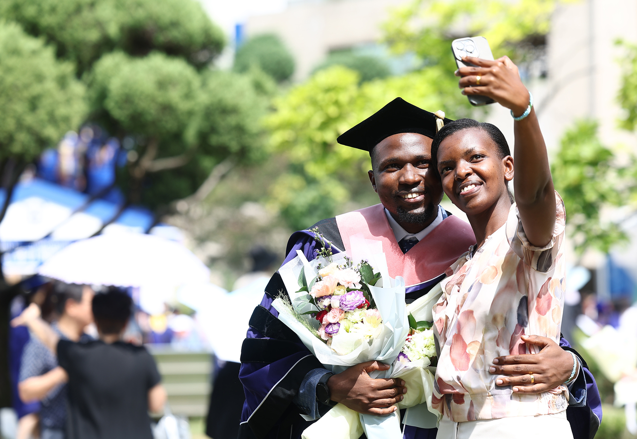 A graduate poses for a commemorative photo with a companion during the 79th Commencement Ceremony held at Seoul National University in Gwanak-gu, Seoul, Thursday. (Yonhap)