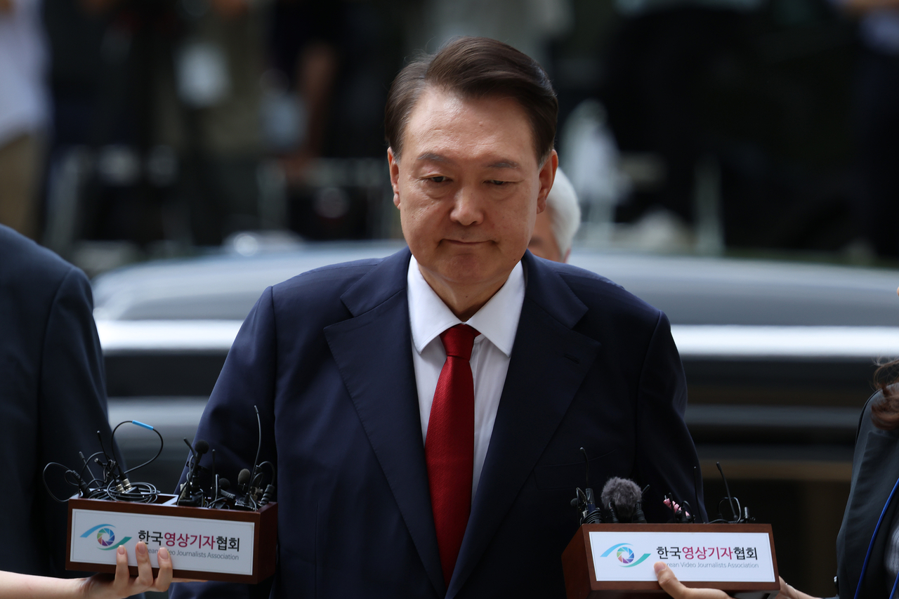 Former President Yoon Suk Yeol enters the Seoul Central District Court in Seocho-gu, Seoul, on July 9 to attend a warrant hearing, taking questions from reporters on his way in. (Pool photo)