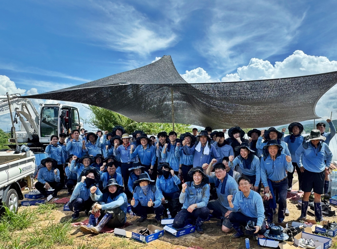 HD Hyundai Oilbank employees take a commemorative photo after volunteering for flood relief efforts in Haemi-myeon, South Chungcheong Province. (HD Hyundai Oilbank)