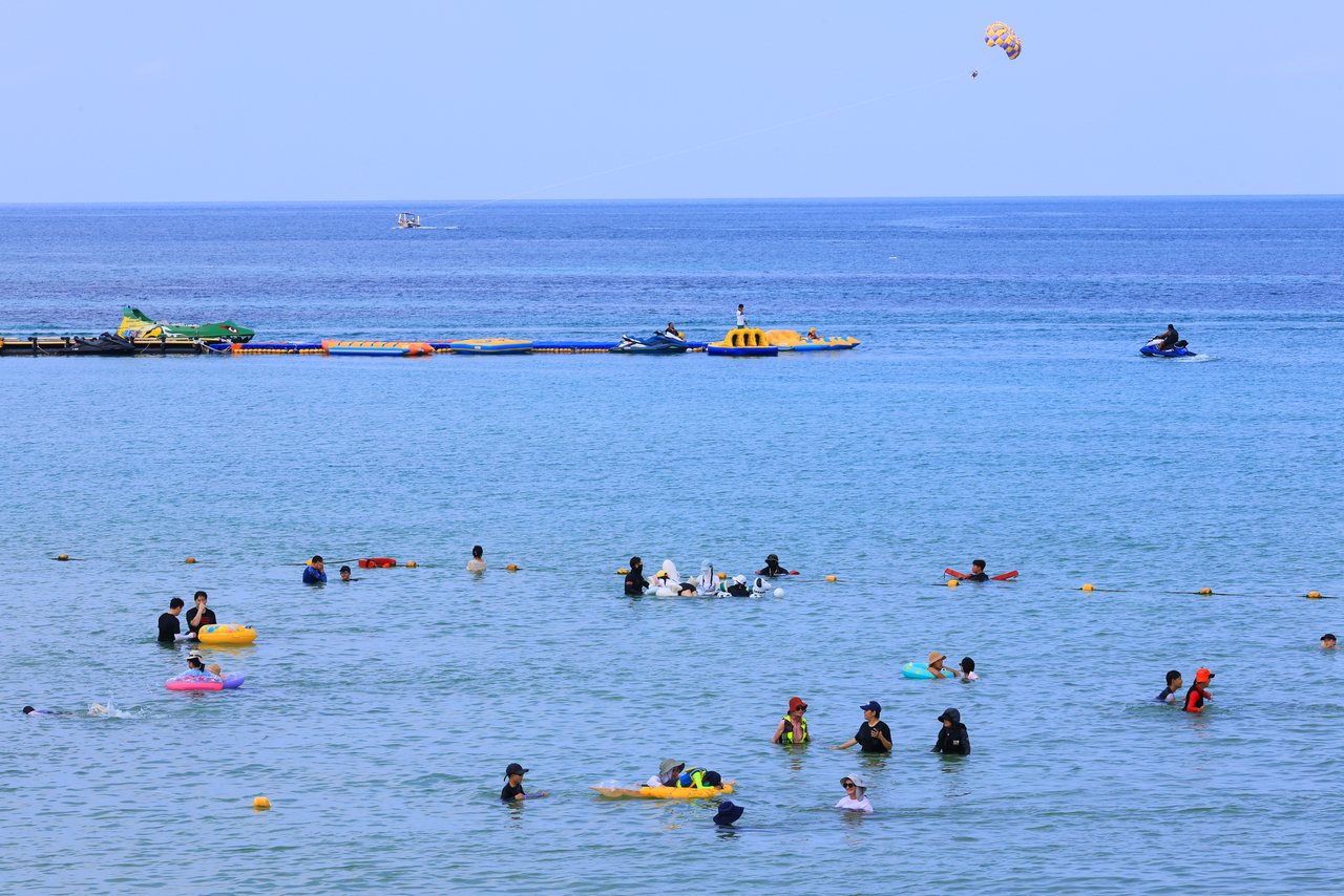 Visitors swim at Hamdeok Beach on Jeju Island, Saturday. (Yonhap)