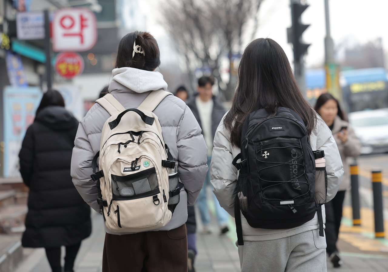 몸이 불편하거나 질병이 있는 가족을 부양하기 위해 자신을 희생해 가족을 돌보는 청년들이 있다. 정부는 이들 가족돌봄청년을 전국적으로 10만여명쯤 되는 것으로 추정한다. 보건복지부의 2022년 실태조사에 따르면 가족돌봄청년 중 ‘미래 계획에 어려움을 겪는다’고 응답한 이들의 비율은 약 36.7%였다. 사진은 지난 1월 서울의 한 학원가에 시험을 준비하는 청년들이 걸어가고 있는 모습. [연합]