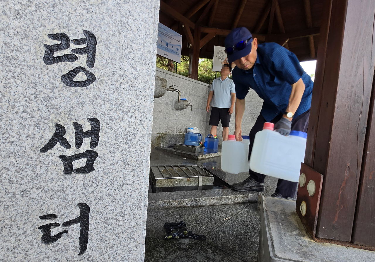Civilians collect water from the Daegwallyeong Fountain for drinking and daily use in Gangneung, Gangwon Province, Sunday, as the water levels at the Obong Reservoir responsible for supplying a majority of the city’s tap and industrial water marked a record low at 14.9 percent that day. (Yonhap)